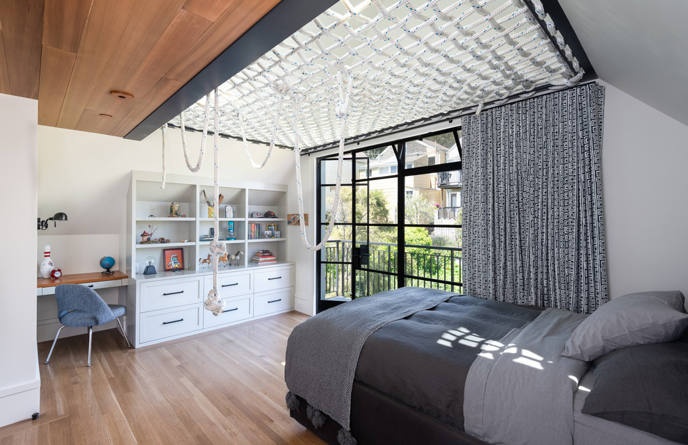 Photo of a transitional kids' bedroom for boys in San Francisco with white walls, medium hardwood floors and brown floor.