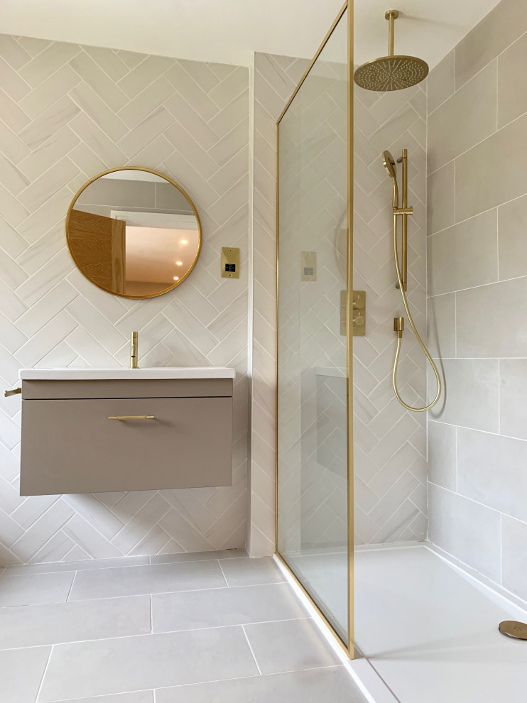 This is an example of an expansive modern kids bathroom in Hertfordshire with flat-panel cabinets, beige cabinets, a wall-mount toilet, porcelain floors, an open shower and a floating vanity.