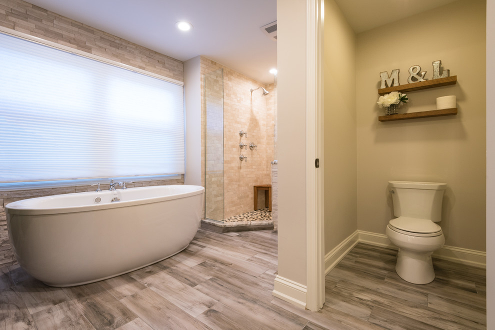 Inspiration for a large transitional master bathroom in Chicago with recessed-panel cabinets, dark wood cabinets, a freestanding tub, a double shower, a two-piece toilet, beige tile, subway tile, beige walls, porcelain floors, an undermount sink, granite benchtops, grey floor and an open shower.