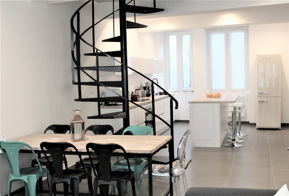 Photo of a modern open plan dining in Lyon with white walls, no fireplace and grey floor.