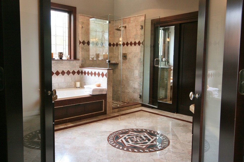 Large transitional master multicolored tile and stone tile marble floor drop-in bathtub photo in Houston with an undermount sink, recessed-panel cabinets, dark wood cabinets, granite countertops, a one-piece toilet and gray walls