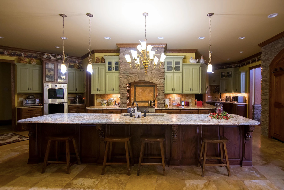 Large mountain style u-shaped porcelain tile and beige floor eat-in kitchen photo with an undermount sink, raised-panel cabinets, green cabinets, granite countertops, beige backsplash, porcelain backsplash, stainless steel appliances, an island and multicolored countertops