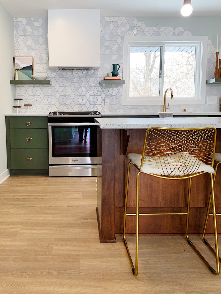 This is an example of a mid-sized midcentury l-shaped open plan kitchen in Minneapolis with a drop-in sink, flat-panel cabinets, green cabinets, onyx benchtops, grey splashback, ceramic splashback, stainless steel appliances, light hardwood floors, with island, brown floor and white benchtop.