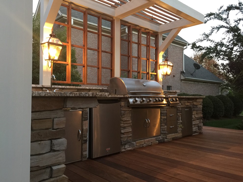 Design ideas for a large traditional backyard patio in Charlotte with an outdoor kitchen, decking and a pergola.
