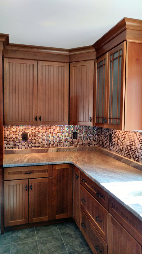 Inspiration for a mid-sized arts and crafts l-shaped separate kitchen in Manchester with beaded inset cabinets, medium wood cabinets, granite benchtops, multi-coloured splashback, glass tile splashback, cement tiles, with island and grey floor.