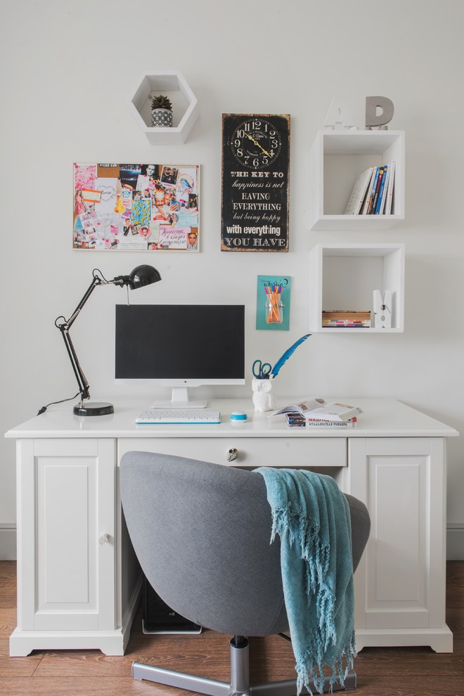 Scandinavian study room in Moscow with white walls, medium hardwood floors, a freestanding desk and brown floor.