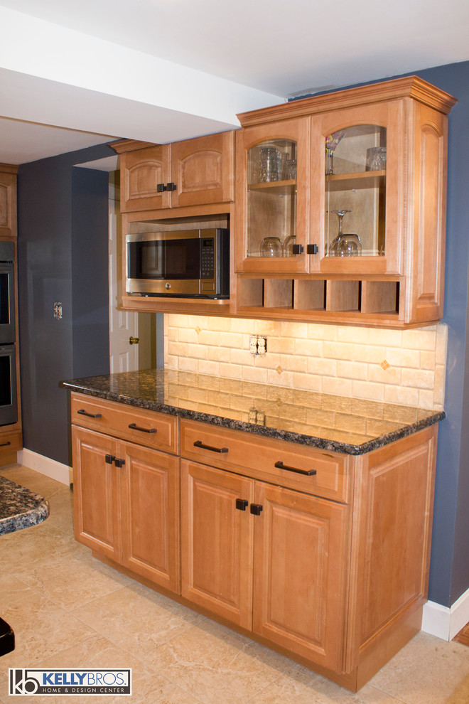 Example of a large transitional l-shaped ceramic tile eat-in kitchen design in Cincinnati with an undermount sink, raised-panel cabinets, light wood cabinets, granite countertops, beige backsplash, stone tile backsplash, stainless steel appliances and an island
