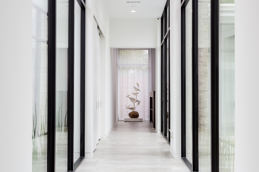 Modern hallway in Dallas with white walls and porcelain floors.