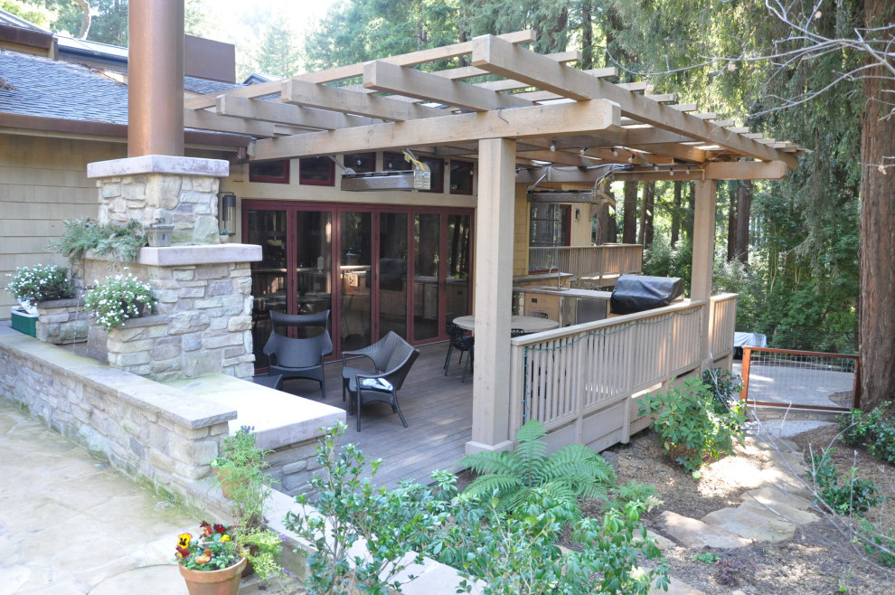 Photo of a mid-sized country ground level deck in Sacramento with with fireplace, a pergola and wood railing.
