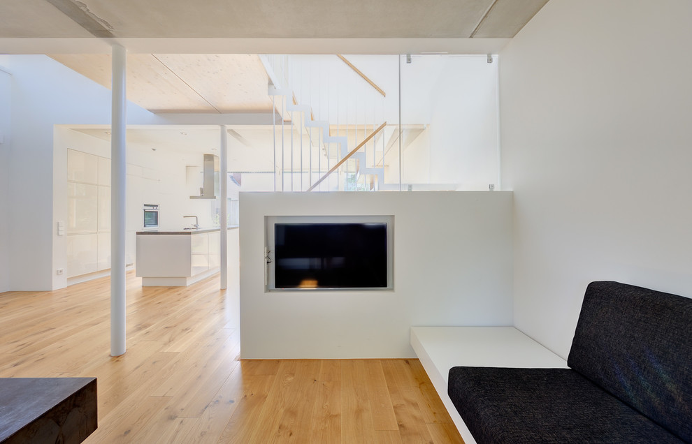 Photo of a contemporary family room in Berlin with white walls and light hardwood floors.