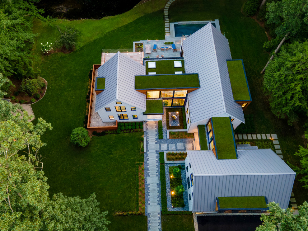 Свежая идея для дизайна: двухэтажный, деревянный, белый частный загородный дом в стиле кантри с двускатной крышей, металлической крышей, серой крышей и отделкой планкеном - отличное фото интерьера