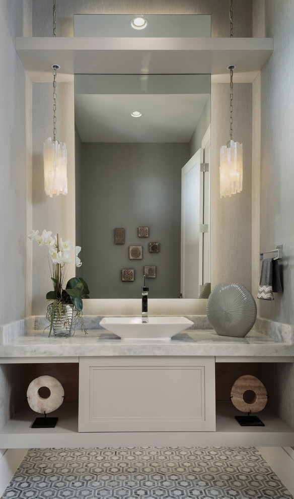 Inspiration for a mid-sized transitional powder room in Miami with recessed-panel cabinets, white cabinets, green walls, cement tiles, a vessel sink, engineered quartz benchtops, grey floor and grey benchtops.