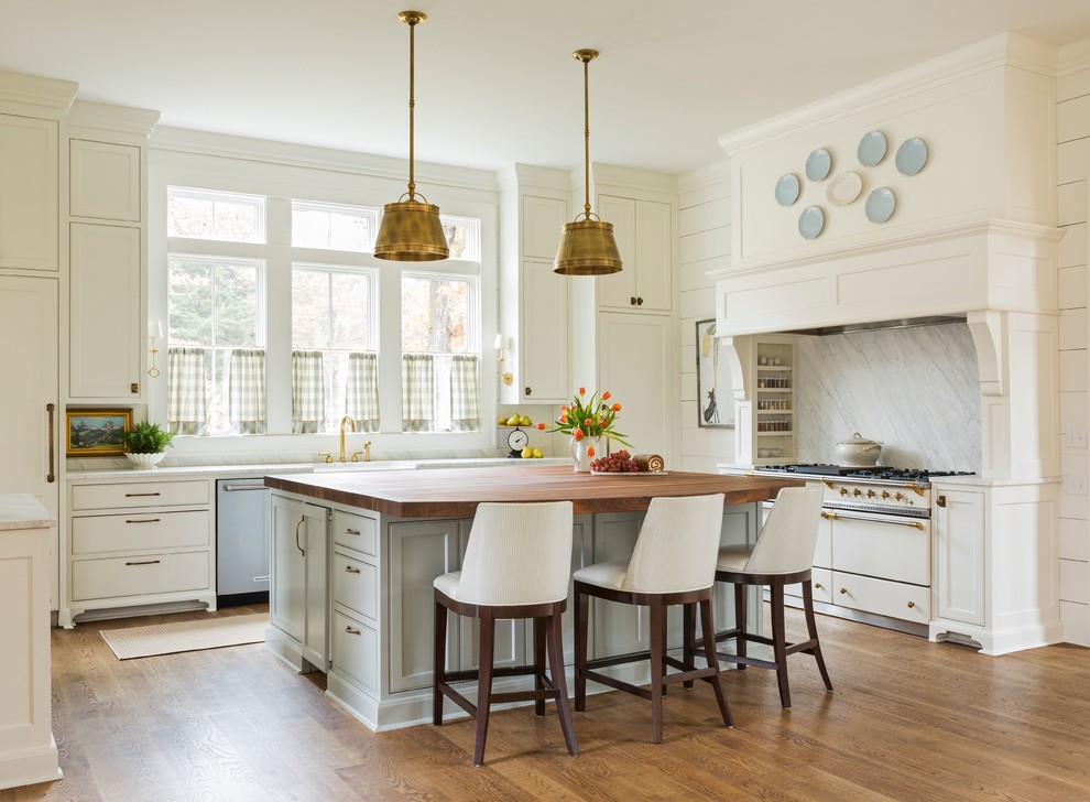 This is an example of a large country single-wall separate kitchen in Little Rock with a farmhouse sink, white cabinets, stone slab splashback, medium hardwood floors, with island, brown floor, white benchtop, recessed-panel cabinets, marble benchtops, grey splashback and panelled appliances.