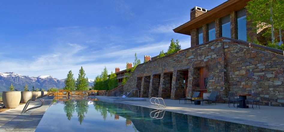 Example of a large mountain style backyard concrete and rectangular lap hot tub design in Jackson