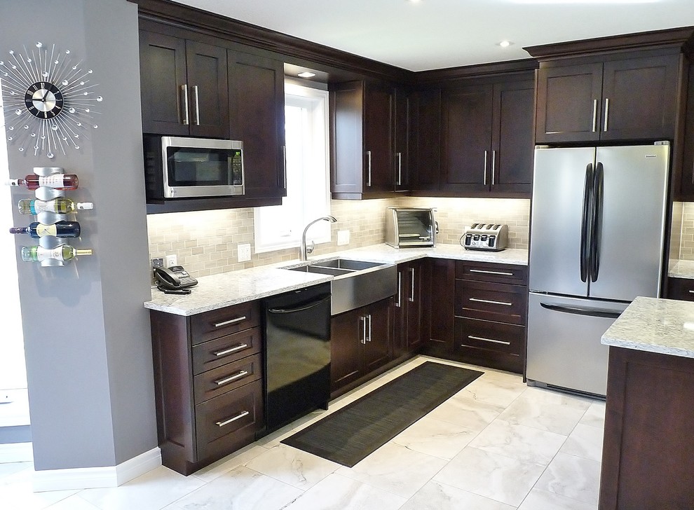 This is an example of a large contemporary l-shaped kitchen in Toronto with an undermount sink, shaker cabinets, dark wood cabinets, granite benchtops, beige splashback, subway tile splashback, stainless steel appliances and ceramic floors.