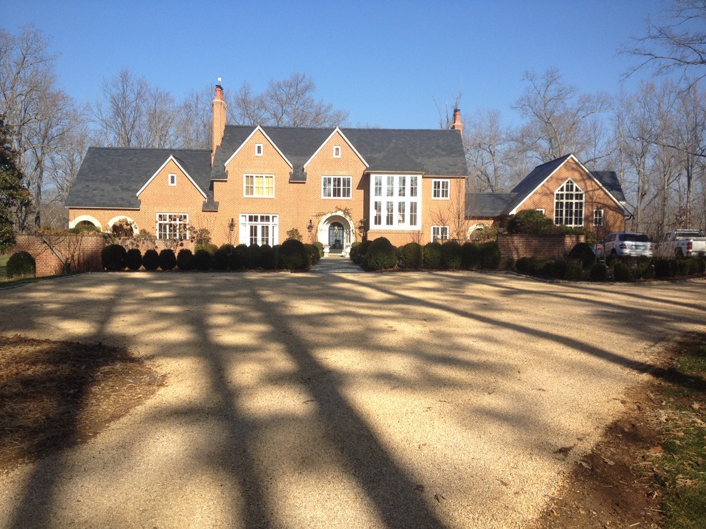 This is an example of a mid-sized traditional front yard driveway in Other with gravel.