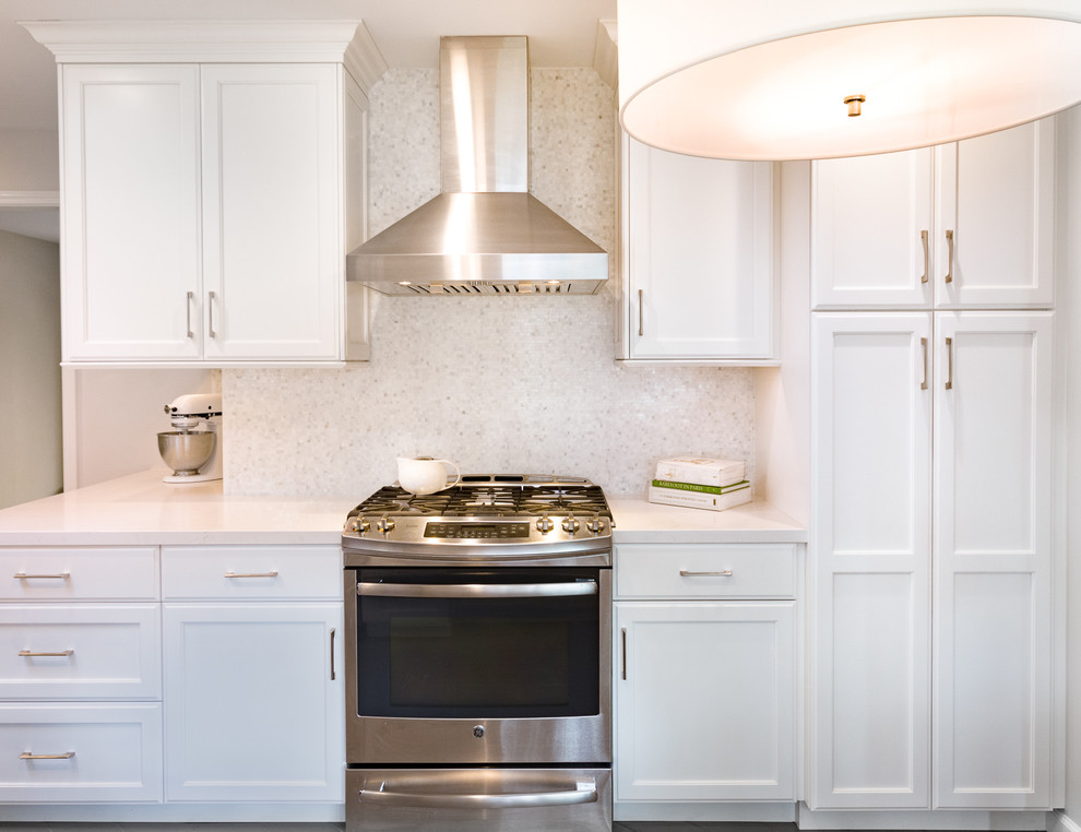 Inspiration for a mid-sized traditional l-shaped eat-in kitchen in San Francisco with an undermount sink, shaker cabinets, white cabinets, white splashback, stainless steel appliances and no island.