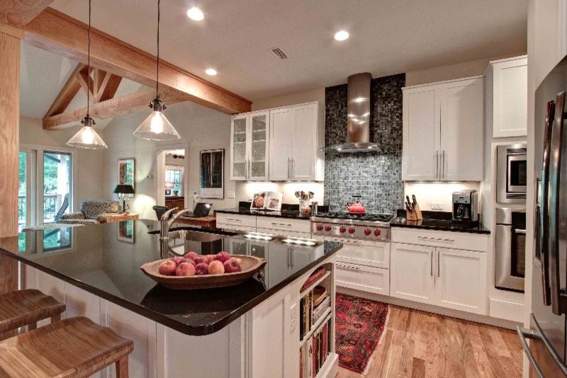 Example of a mid-sized transitional l-shaped light wood floor open concept kitchen design with an undermount sink, shaker cabinets, white cabinets, granite countertops, multicolored backsplash, stainless steel appliances and an island