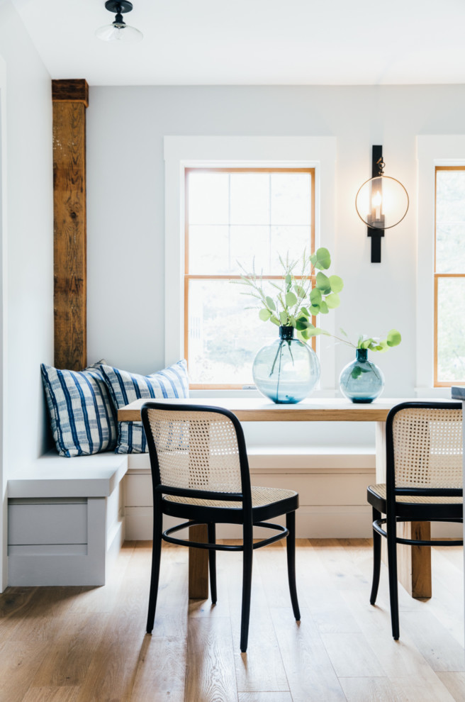 Design ideas for a country dining room in Portland Maine with white walls and light hardwood floors.