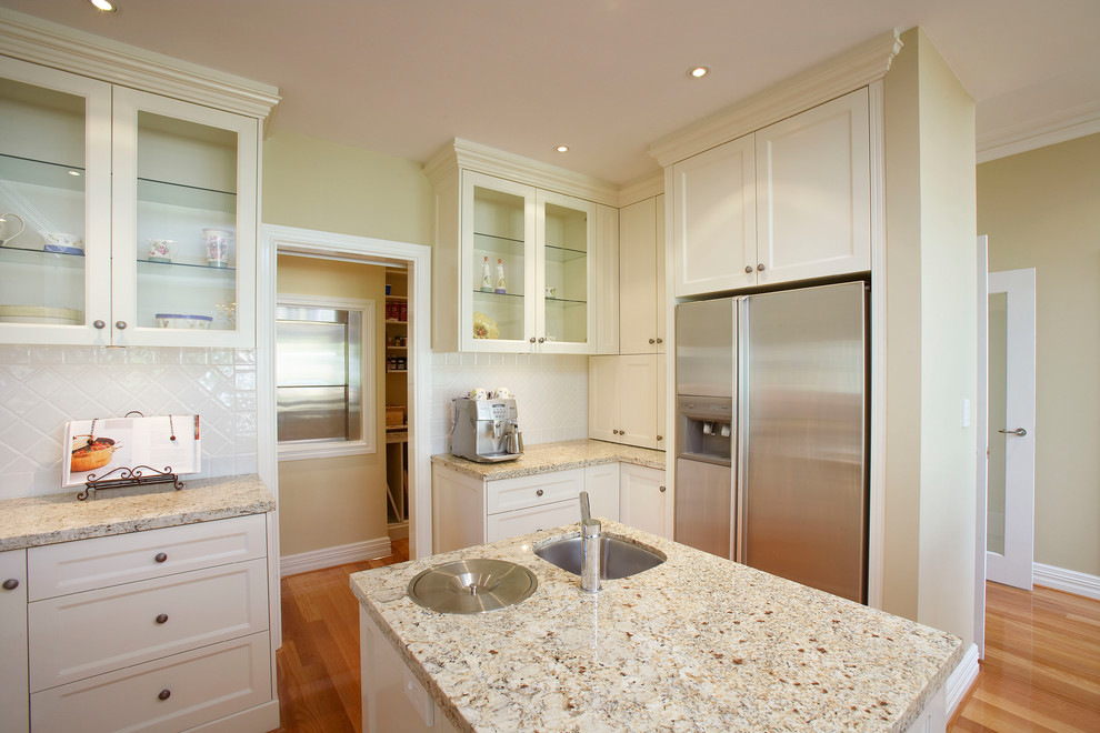 Design ideas for a traditional kitchen in Perth with an undermount sink, shaker cabinets, white cabinets, granite benchtops, white splashback, porcelain splashback, stainless steel appliances, with island and multi-coloured benchtop.