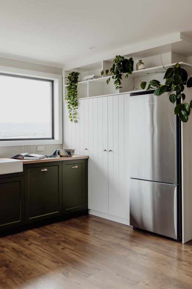 Inspiration for a transitional kitchen in Hobart with a farmhouse sink, shaker cabinets, green cabinets, wood benchtops, white splashback, cement tile splashback and stainless steel appliances.