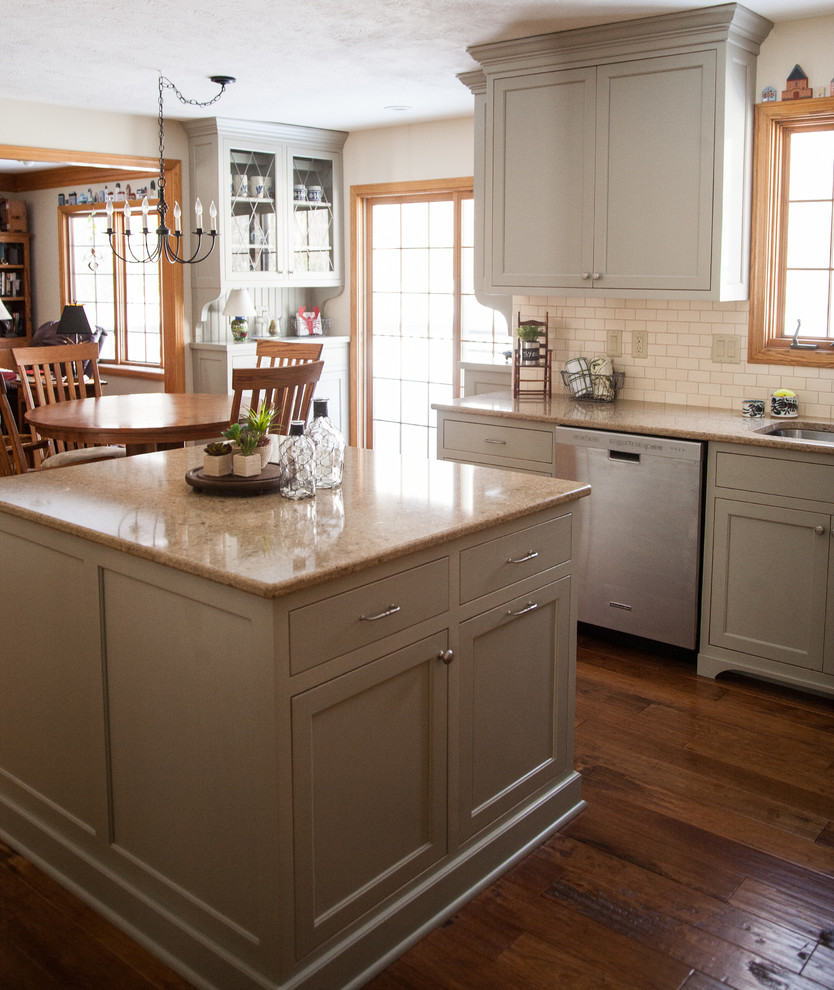 Inspiration for a mid-sized transitional u-shaped medium tone wood floor eat-in kitchen remodel in Cleveland with an undermount sink, gray cabinets, quartz countertops, beige backsplash, ceramic backsplash, stainless steel appliances, an island and shaker cabinets