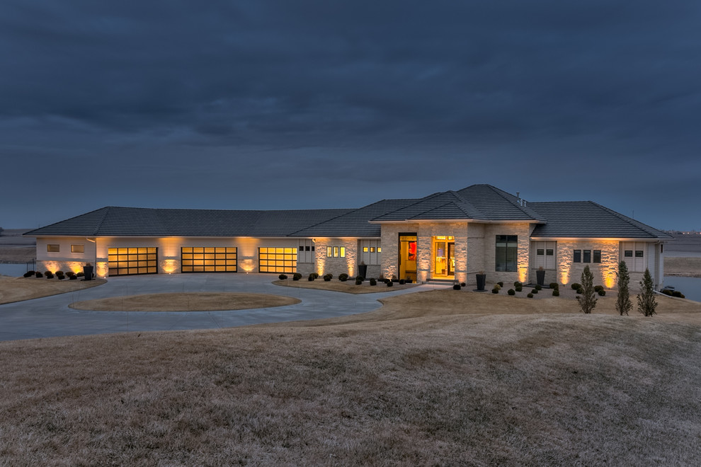 Expansive contemporary one-storey grey house exterior in Omaha with stone veneer.