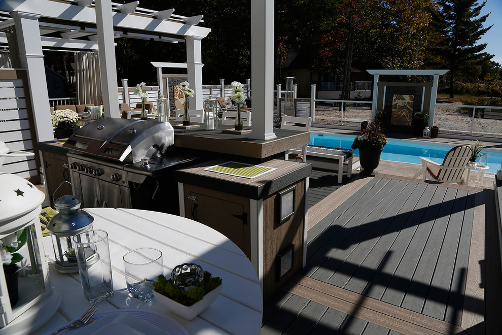 Large beach style courtyard deck in Toronto with a pergola.