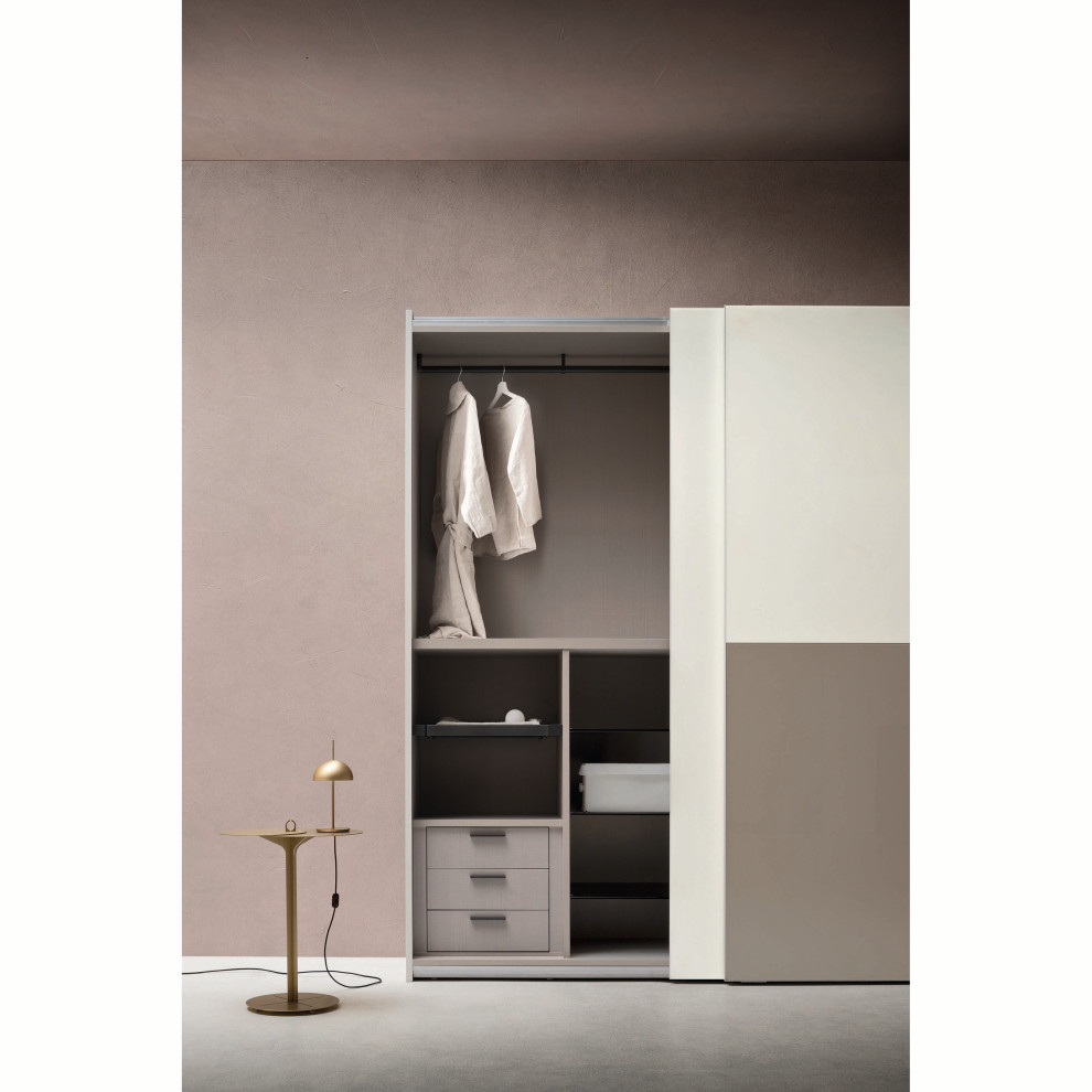 Contemporary gender-neutral storage and wardrobe with glass-front cabinets and beige cabinets.