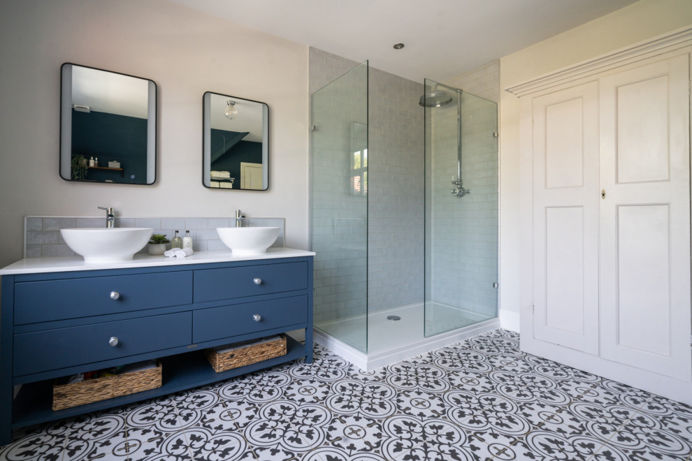 Inspiration för stora moderna vitt en-suite badrum, med skåp i shakerstil, blå skåp, ett fristående badkar, en dubbeldusch, en vägghängd toalettstol, grå kakel, keramikplattor, klinkergolv i keramik, ett piedestal handfat, granitbänkskiva, grått golv och med dusch som är öppen