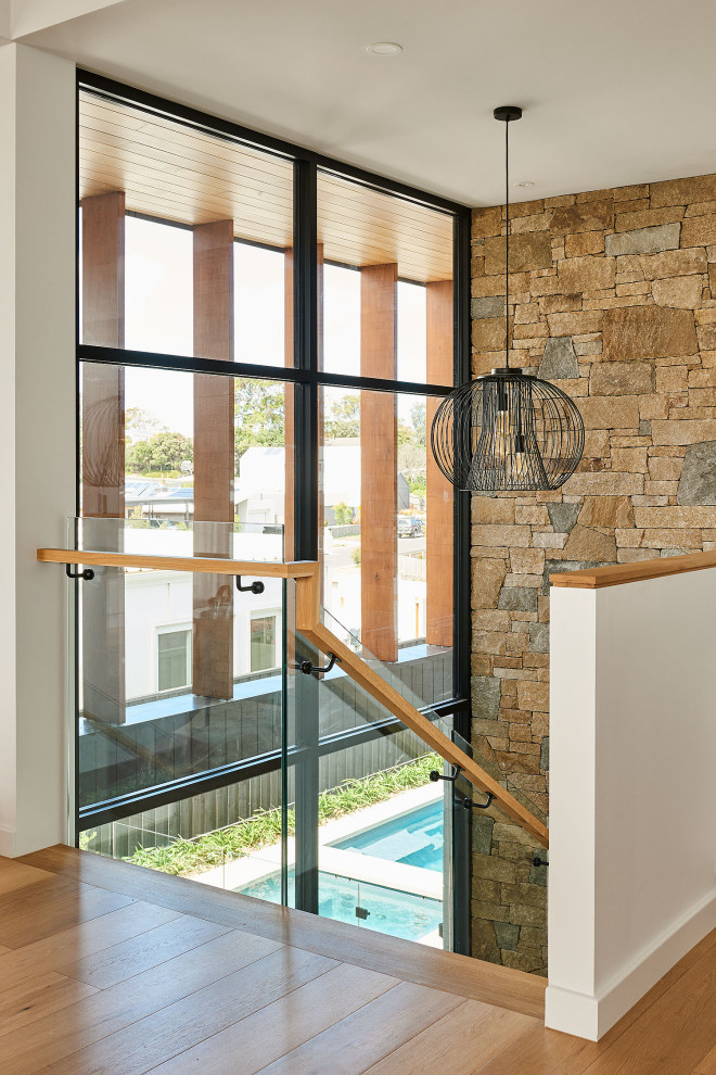 Photo of a large coastal wood u-shaped glass railing staircase in Geelong.