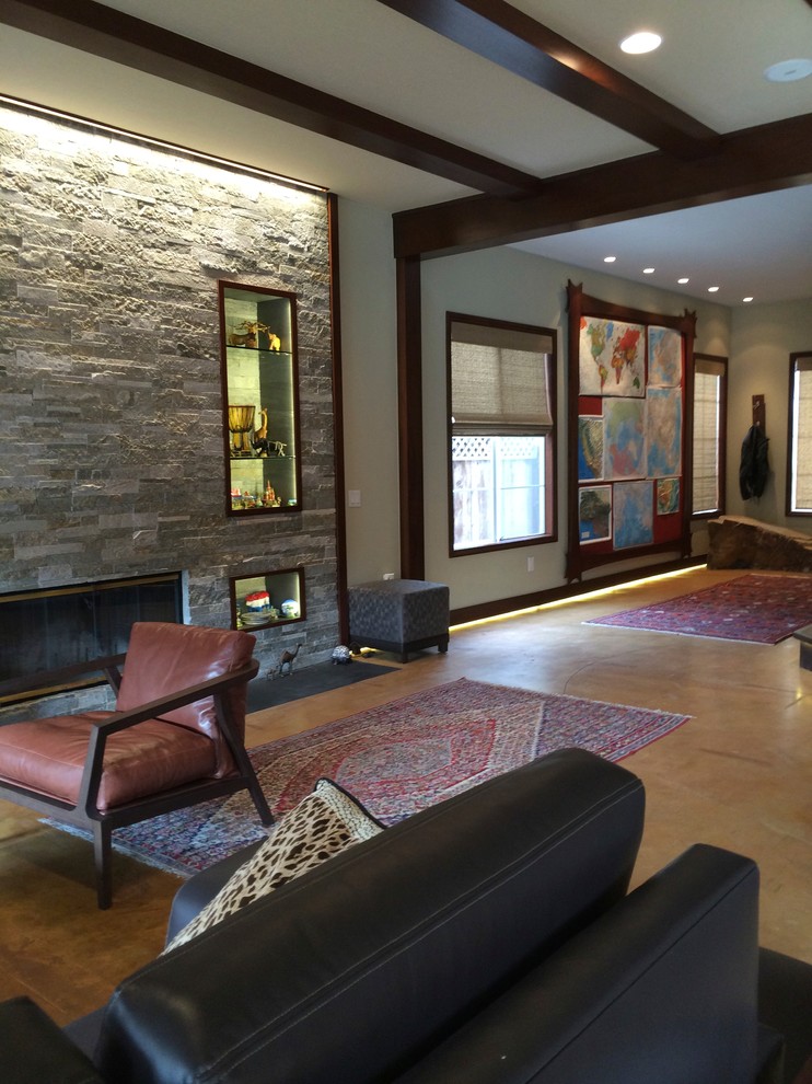 This is an example of a mid-sized arts and crafts family room in Orange County with green walls, concrete floors, no fireplace and a stone fireplace surround.