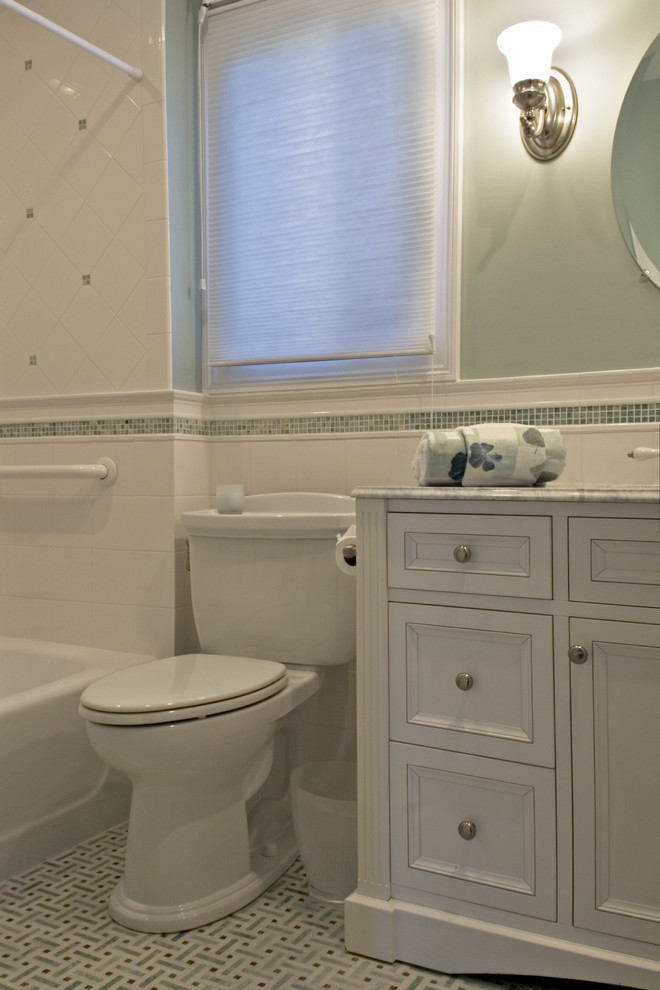 Design ideas for a mid-sized traditional bathroom in Bridgeport with an undermount sink, furniture-like cabinets, white cabinets, marble benchtops, an alcove tub, a shower/bathtub combo, a two-piece toilet, white tile, stone tile, green walls and mosaic tile floors.