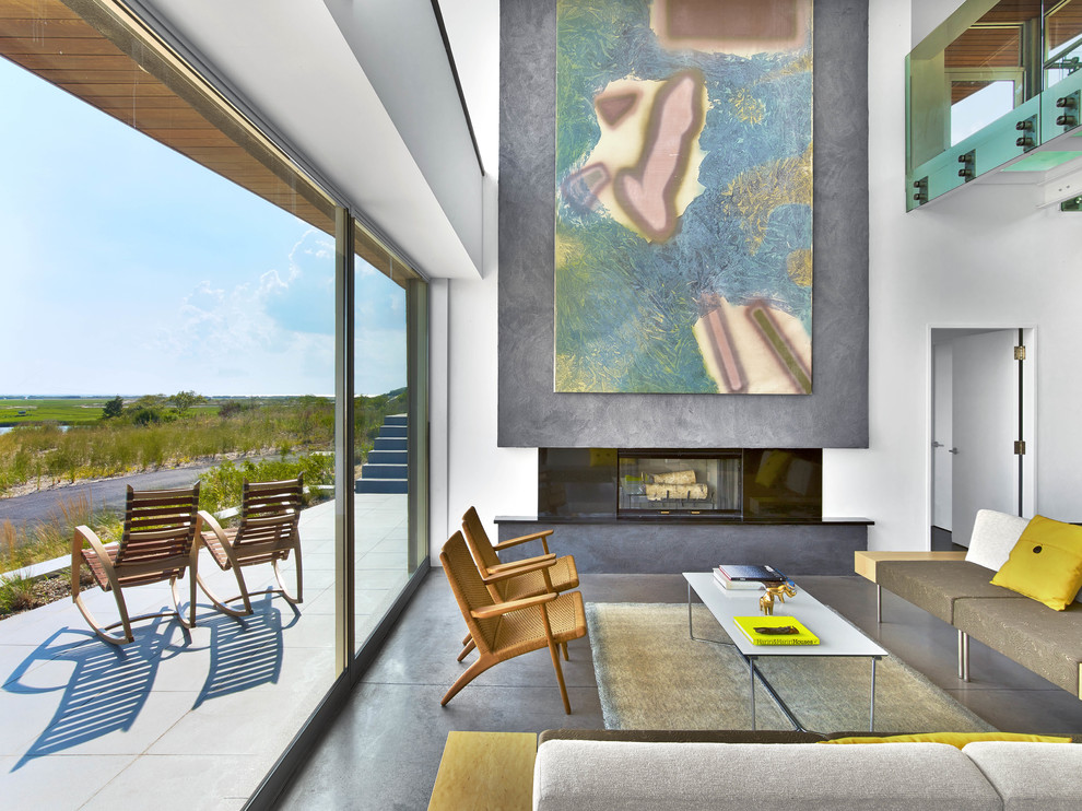 Contemporary open concept living room in New York with white walls, concrete floors, a standard fireplace, a concrete fireplace surround and grey floor.