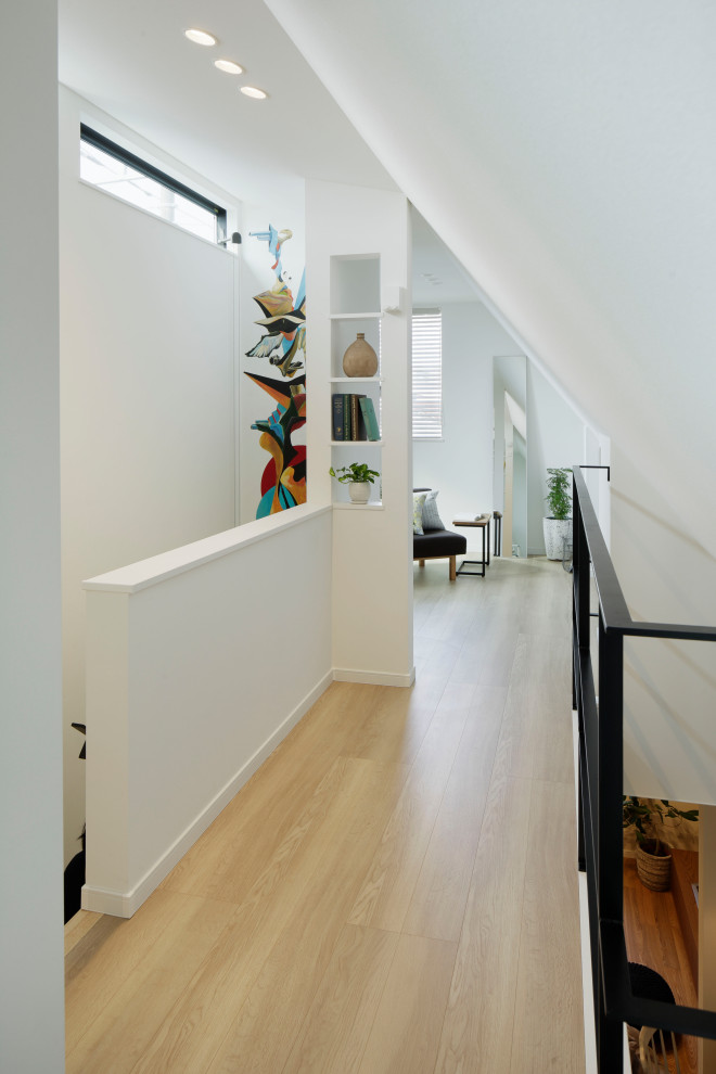 Inspiration för en mellanstor minimalistisk hall, med vita väggar, ljust trägolv och beiget golv