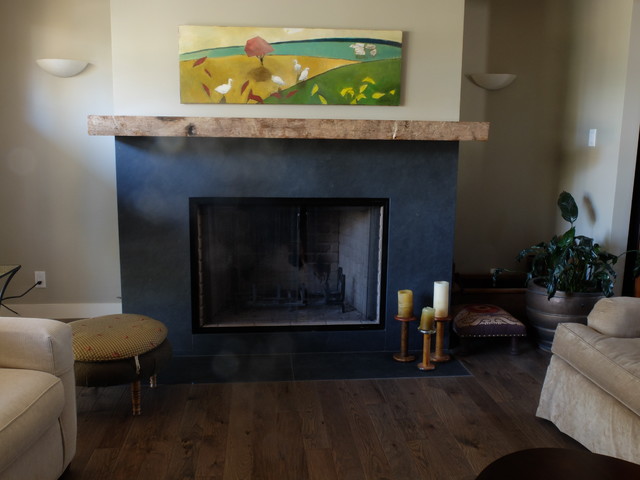 Example of a mid-sized eclectic dark wood floor family room design in Edmonton with beige walls, a standard fireplace, a wood fireplace surround and no tv