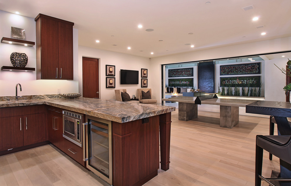 Photo of a contemporary home bar in Orange County with light hardwood floors.