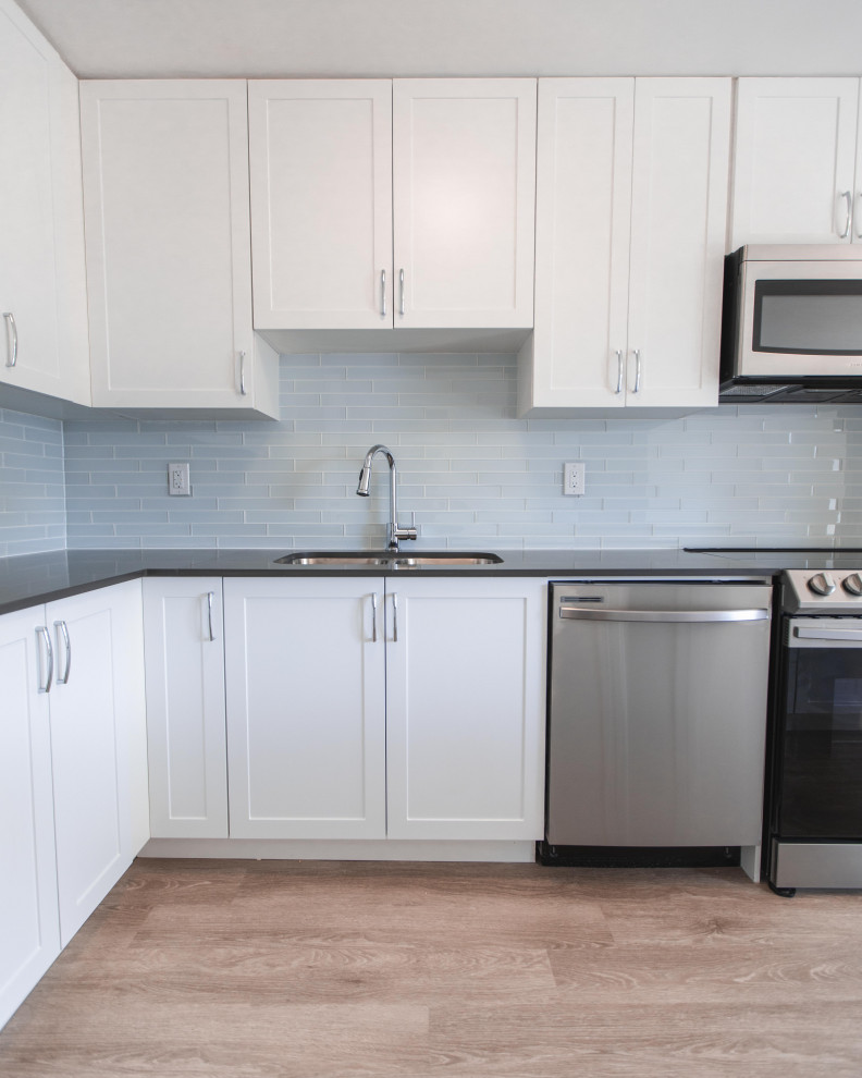 This is an example of a mid-sized modern l-shaped eat-in kitchen in Toronto with beaded inset cabinets, white cabinets and with island.