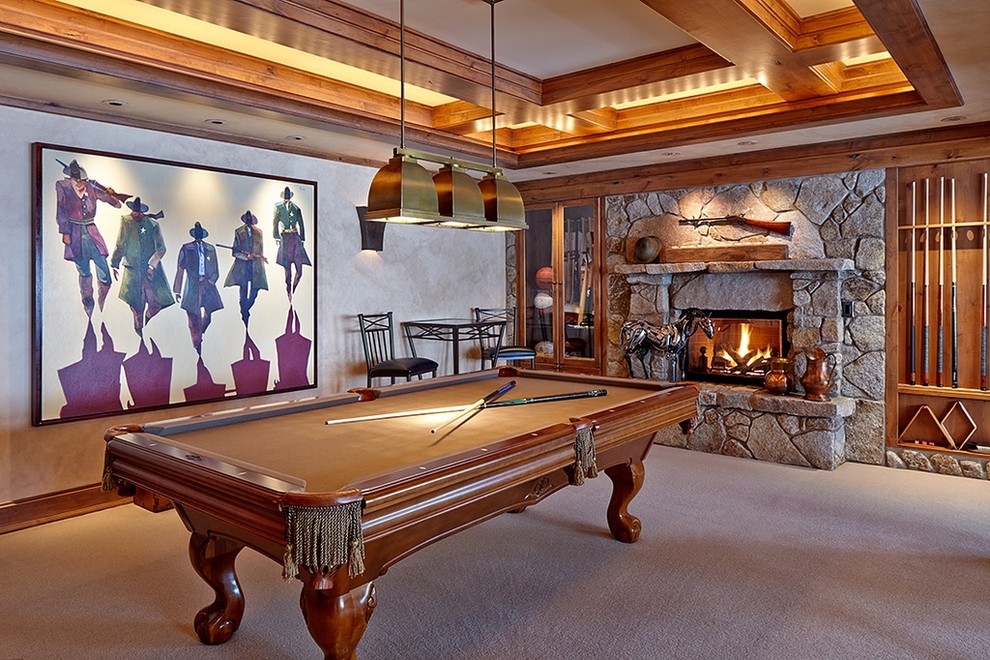 Traditional enclosed family room in Seattle with a game room, beige walls, carpet, a standard fireplace, a stone fireplace surround, no tv and beige floor.