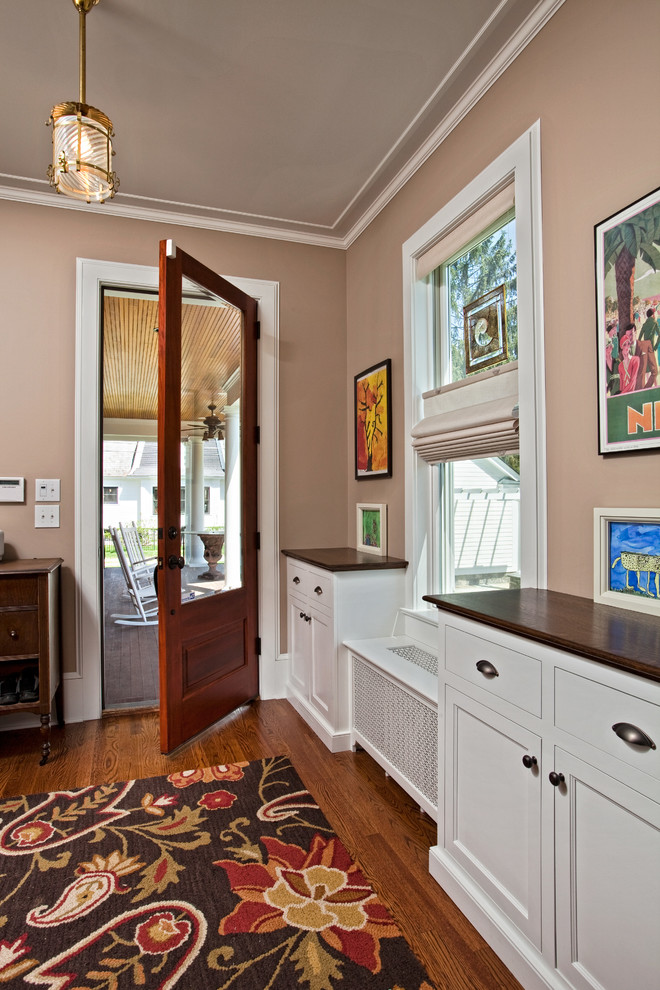 Inspiration for a mid-sized traditional foyer in Boston with beige walls, medium hardwood floors, a single front door and a medium wood front door.