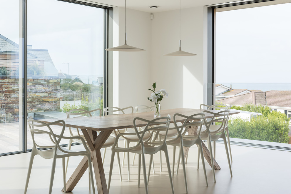 This is an example of a large open plan dining in Cornwall with concrete floors and beige floor.
