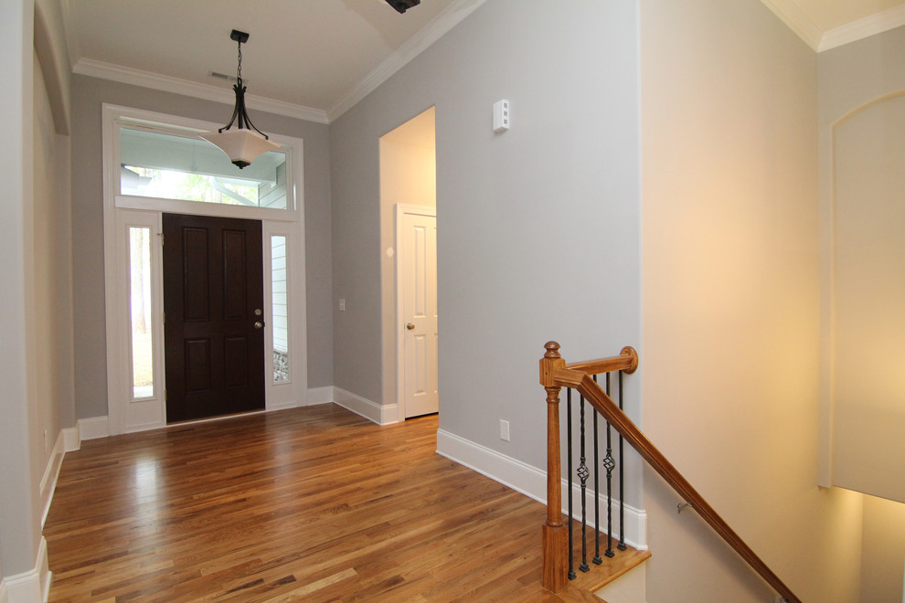 Mid-sized transitional medium tone wood floor front door photo in Raleigh with gray walls and a dark wood front door