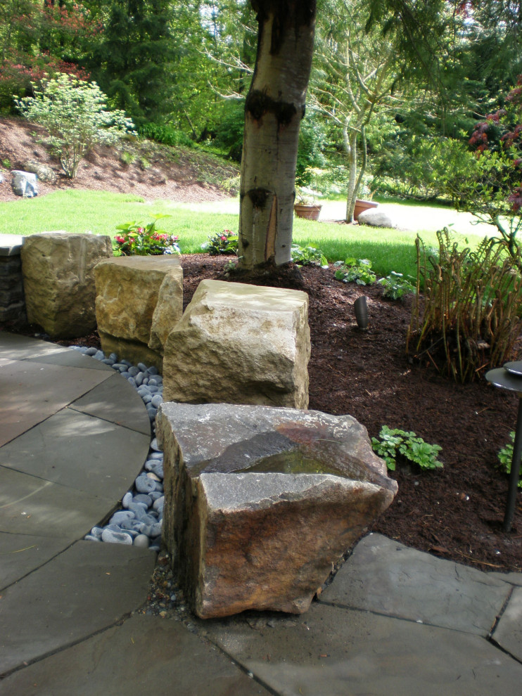 This is an example of a mid-sized contemporary backyard shaded formal garden in Seattle with natural stone pavers.