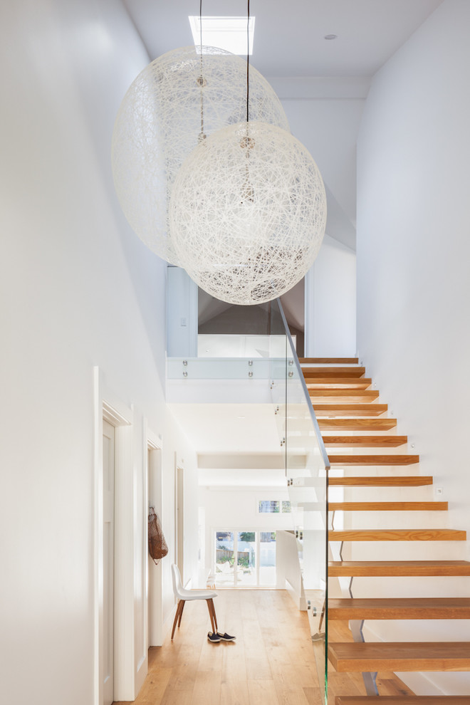 Mid-sized contemporary hallway in Sydney with white walls, medium hardwood floors and brown floor.