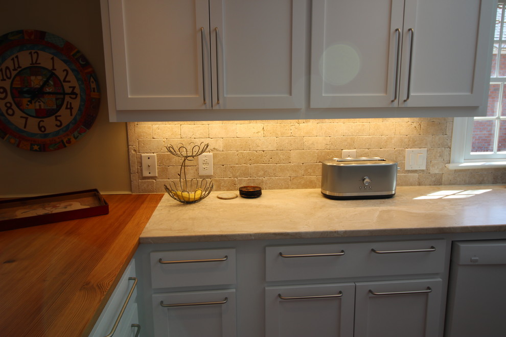 This is an example of a mid-sized transitional u-shaped eat-in kitchen in Other with a farmhouse sink, shaker cabinets, yellow cabinets, marble benchtops, beige splashback, stone tile splashback, stainless steel appliances, medium hardwood floors and with island.