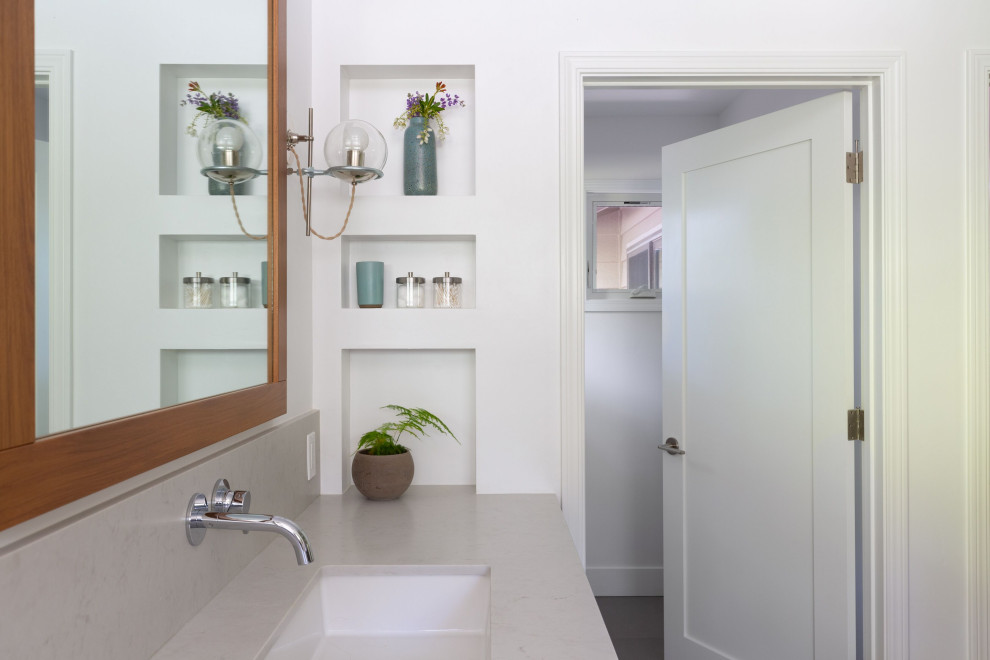 Large transitional master gray tile and ceramic tile ceramic tile and gray floor freestanding bathtub photo with furniture-like cabinets, brown cabinets, a two-piece toilet, white walls, a drop-in sink, quartz countertops and gray countertops