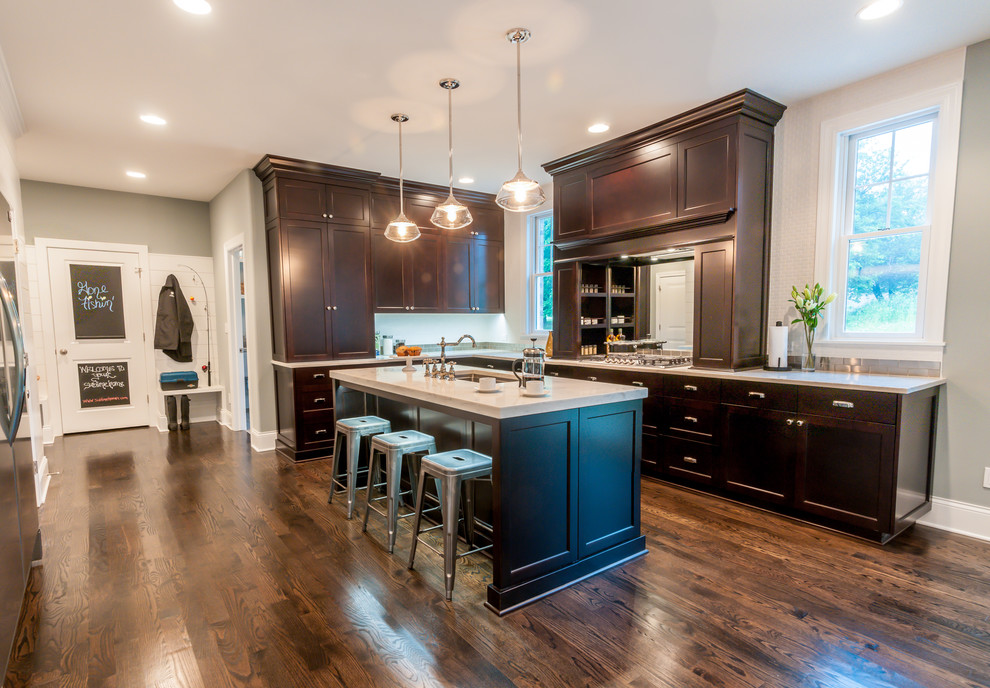 Mid-sized transitional l-shaped dark wood floor eat-in kitchen photo in Chicago with an undermount sink, recessed-panel cabinets, dark wood cabinets, quartzite countertops, white backsplash, ceramic backsplash, stainless steel appliances and an island