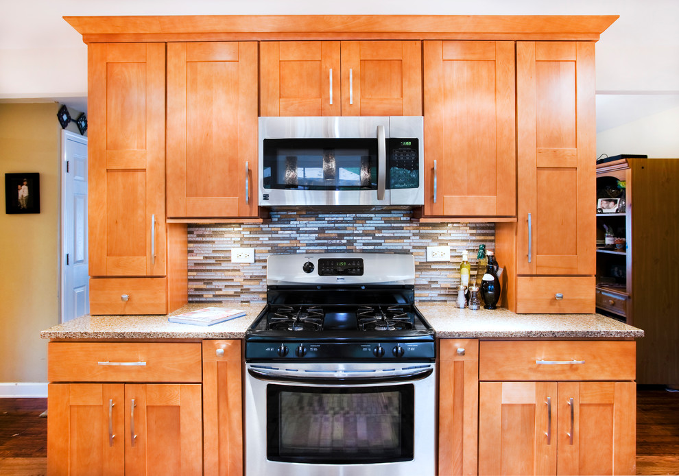 Inspiration for a mid-sized transitional l-shaped medium tone wood floor eat-in kitchen remodel in Chicago with an undermount sink, shaker cabinets, medium tone wood cabinets, quartz countertops, multicolored backsplash, matchstick tile backsplash, stainless steel appliances and no island