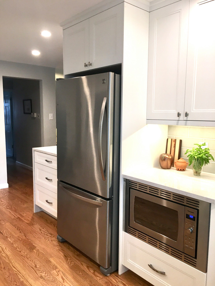 Enclosed kitchen - small transitional u-shaped medium tone wood floor and brown floor enclosed kitchen idea in Denver with a drop-in sink, shaker cabinets, white cabinets, quartz countertops, gray backsplash, subway tile backsplash, stainless steel appliances, a peninsula and white countertops