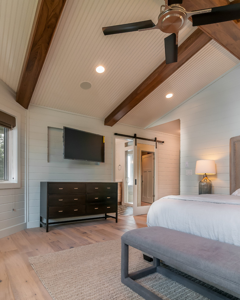 Example of a large transitional master light wood floor and beige floor bedroom design with white walls